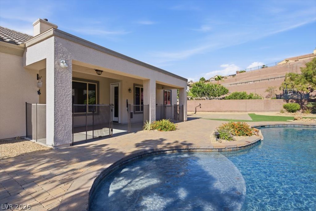 2125 De Rouge Avenue Henderson, NV 89044 - Photo 73 of 96 An inviting backyard oasis awaits with a refreshing pool and covered patio.