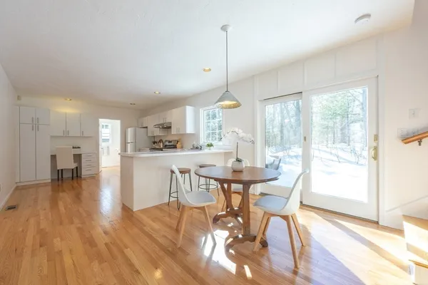 a view of a dining room and livingroom with furniture wooden floor a chandelier