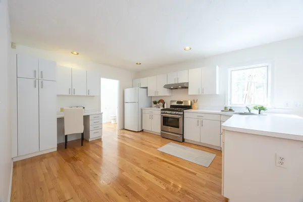 a kitchen with white cabinets and stainless steel appliances