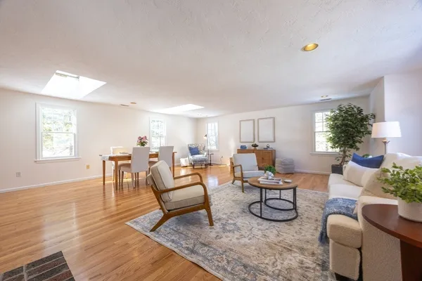 a living room with furniture and a dining table with wooden floor