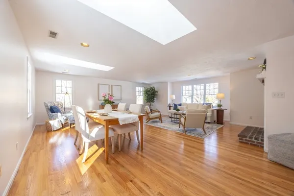 a living room with furniture a wooden floor and next to a window