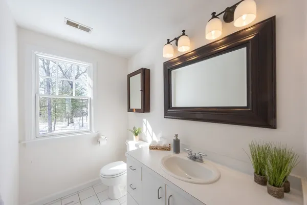 a bathroom with a toilet sink and mirror