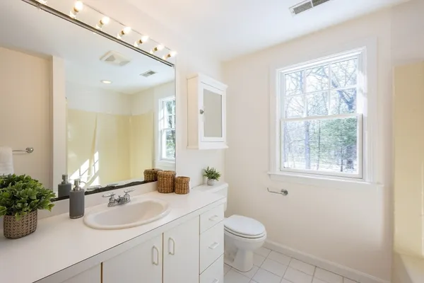 a bathroom with a granite countertop sink a large mirror and a window