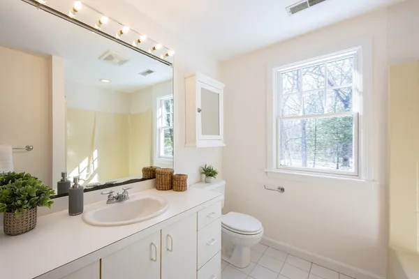 a bathroom with a granite countertop sink a large mirror and a window