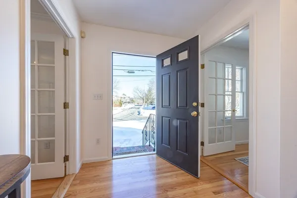 a view of a hallway with wooden floor and a living room
