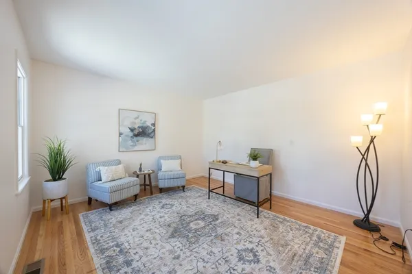 a living room with furniture a rug and a window