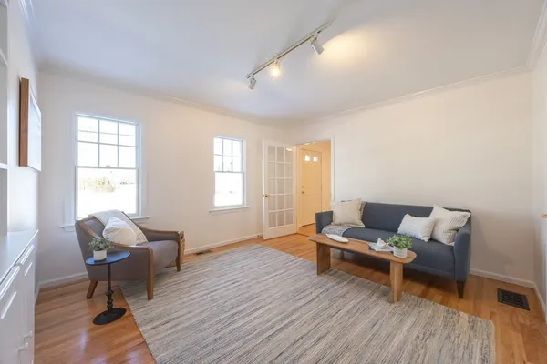 a living room with furniture and a wooden floor
