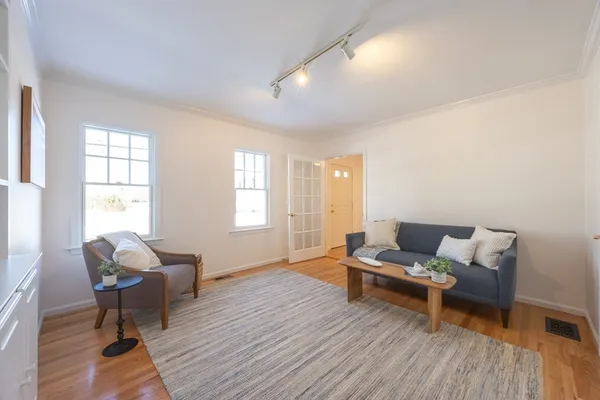 a living room with furniture and a wooden floor