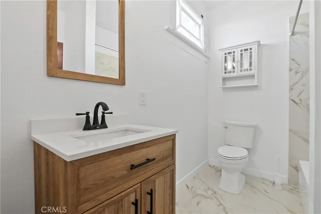 a view of bathroom with a toilet sink and mirror
