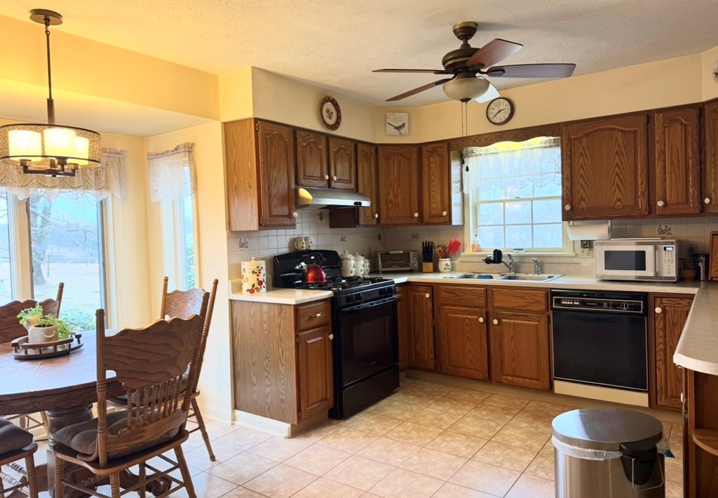 879 Kahle Road Summerville, PA 15864 - Photo 13 of 38 a kitchen with stainless steel appliances granite countertop a sink a stove a refrigerator cabinets and dining table