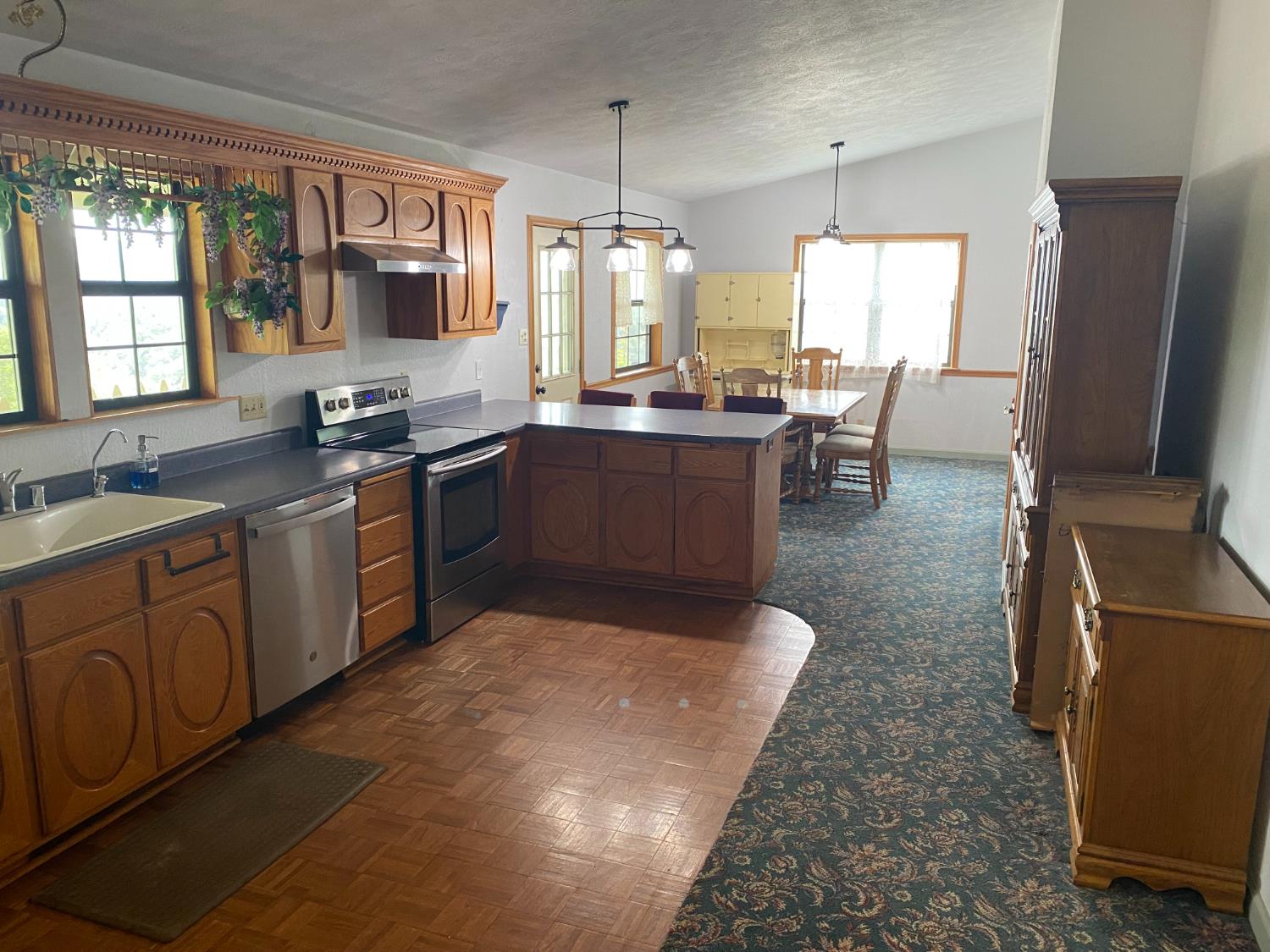 5021 Banbury Cross Road Shingle Springs, CA 95682 - Photo 18 of 92 Kitchen view facing the dedicated dining area. Notice the hanging lights and the seamless continued carpet for thru traffic.