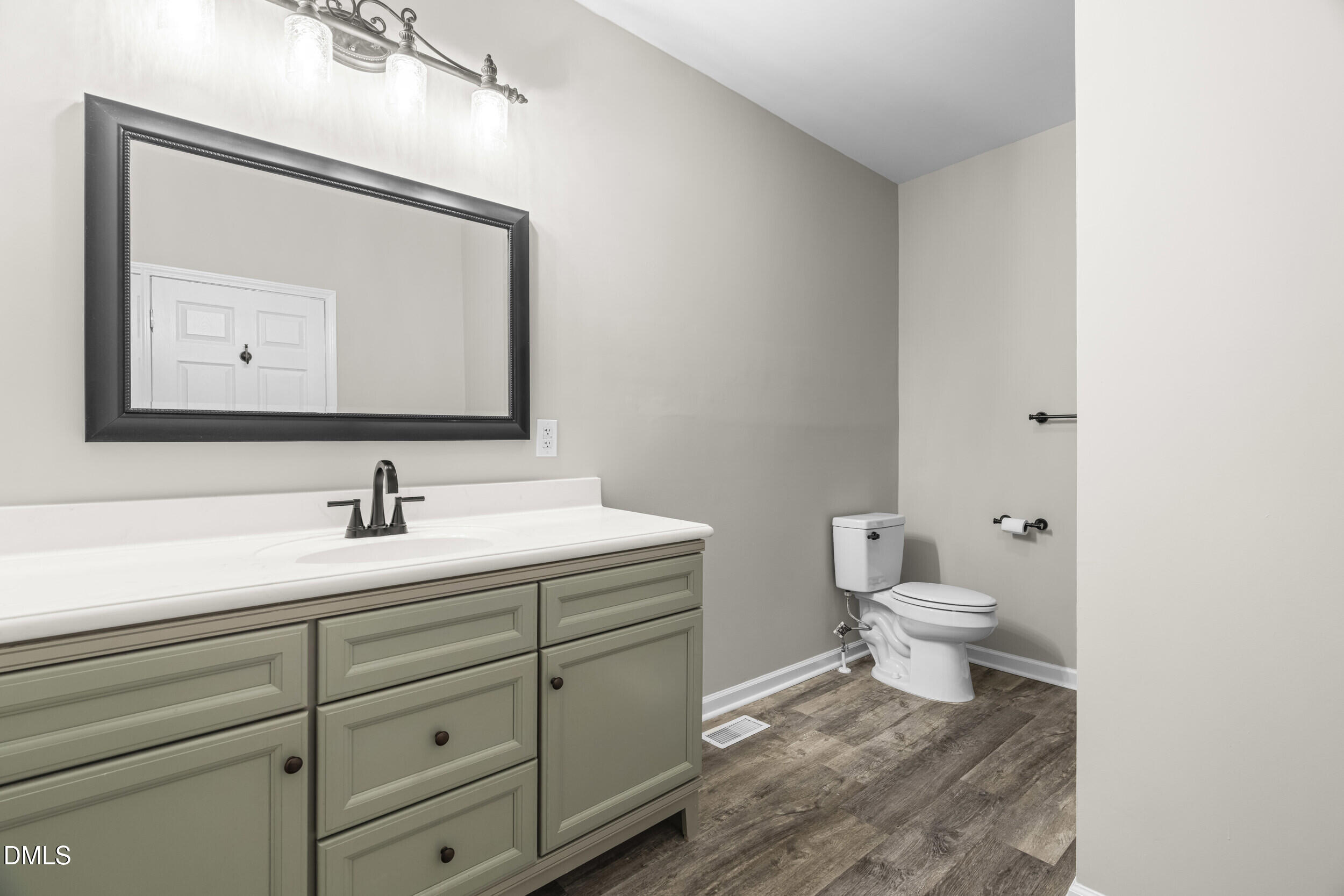 307 East J Street Erwin, NC 28339 - Photo 12 of 27 a bathroom with a toilet sink and mirror