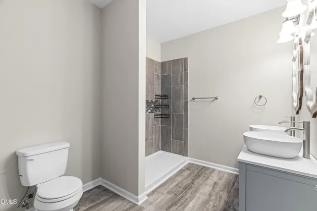 a bathroom with a sink a toilet and shower