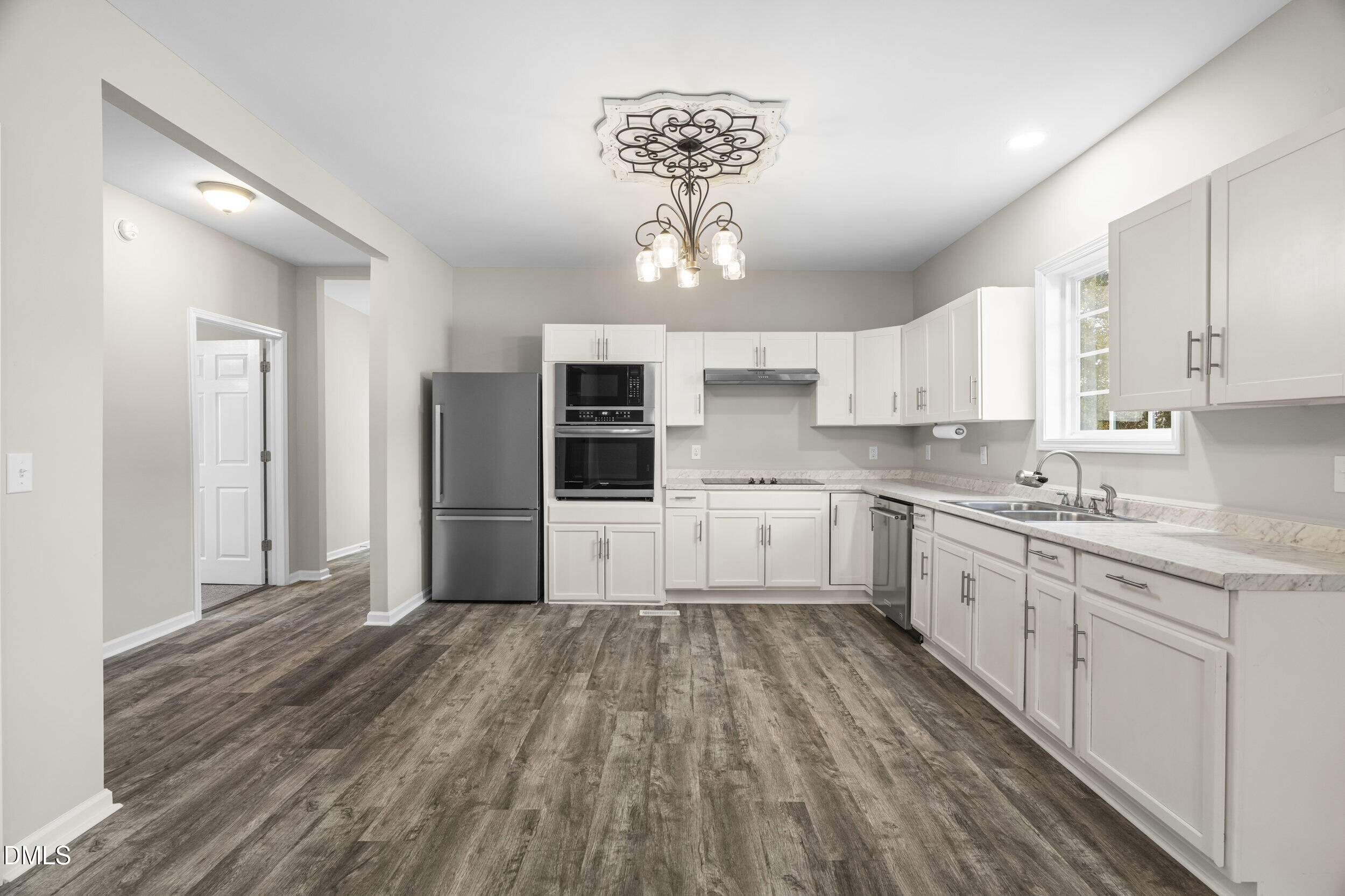 307 East J Street Erwin, NC 28339 - Photo 8 of 27 a kitchen with granite countertop a refrigerator and white cabinets