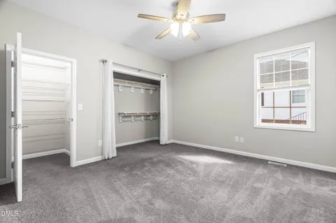 a view of empty room with windows and ceiling fan