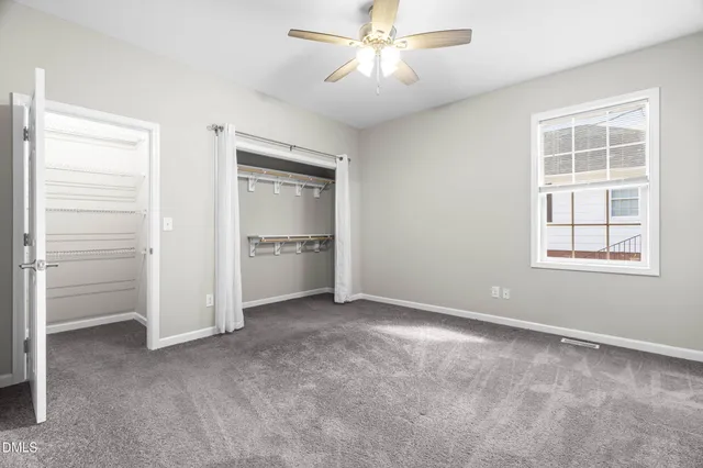 a view of empty room with windows and ceiling fan