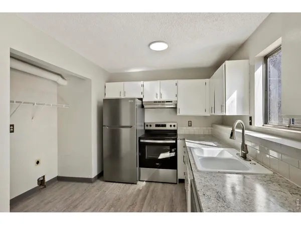 a kitchen with a refrigerator sink and cabinets