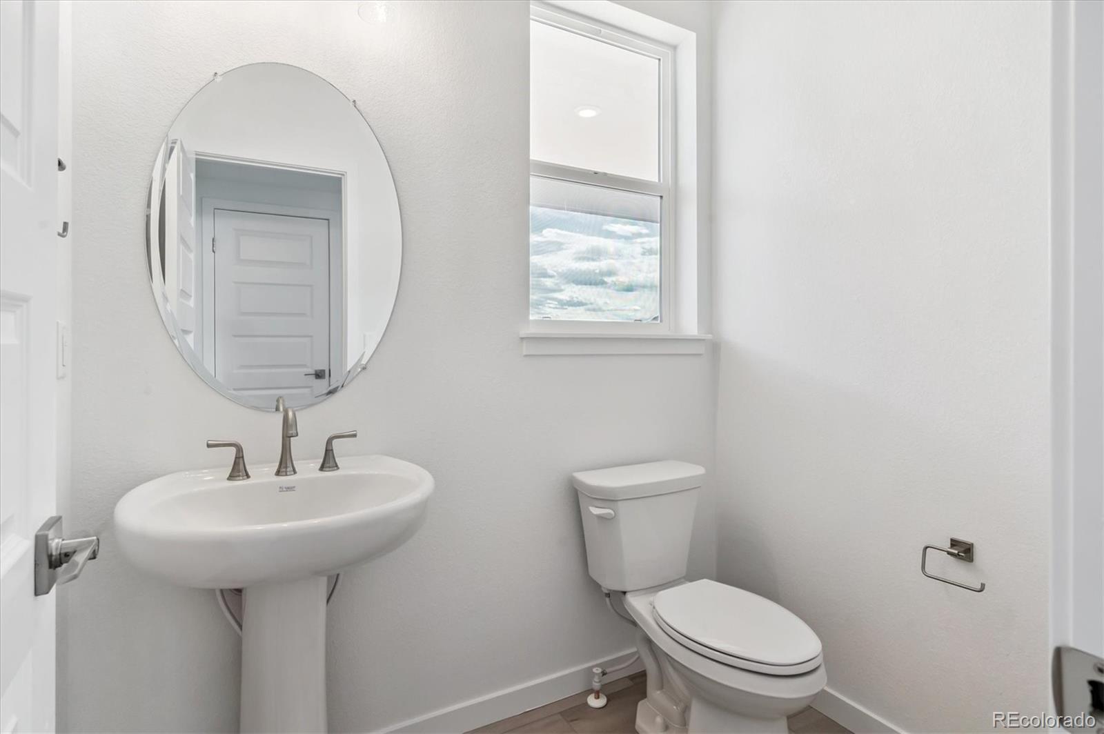 9123 White Ridge Road Englewood, CO 80112 - Photo 14 of 28 a bathroom with a toilet sink and mirror