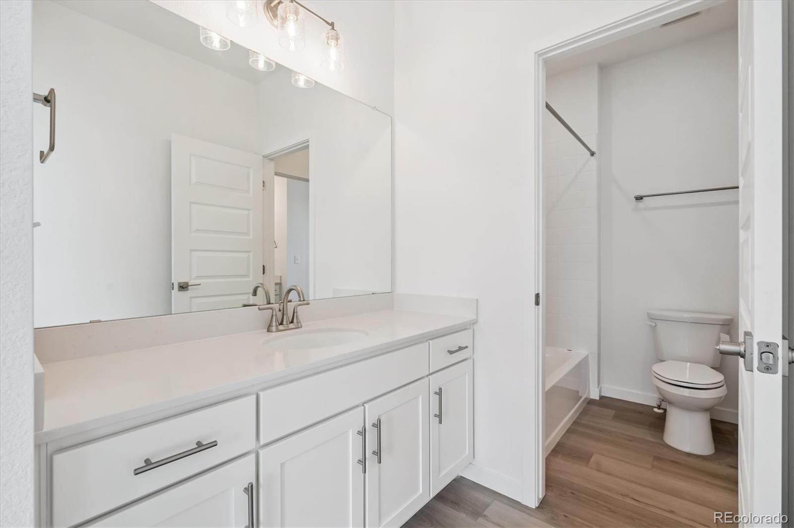 9123 White Ridge Road Englewood, CO 80112 - Photo 17 of 28 a bathroom with a sink a toilet and a large mirror