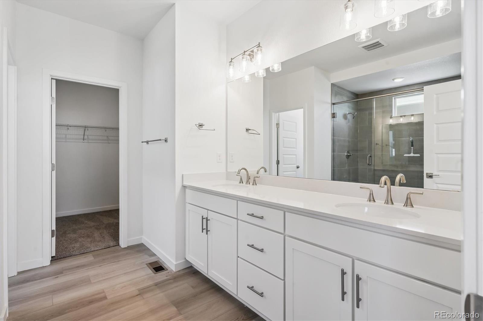 9123 White Ridge Road Englewood, CO 80112 - Photo 22 of 28 a bathroom with a double vanity sink and a mirror