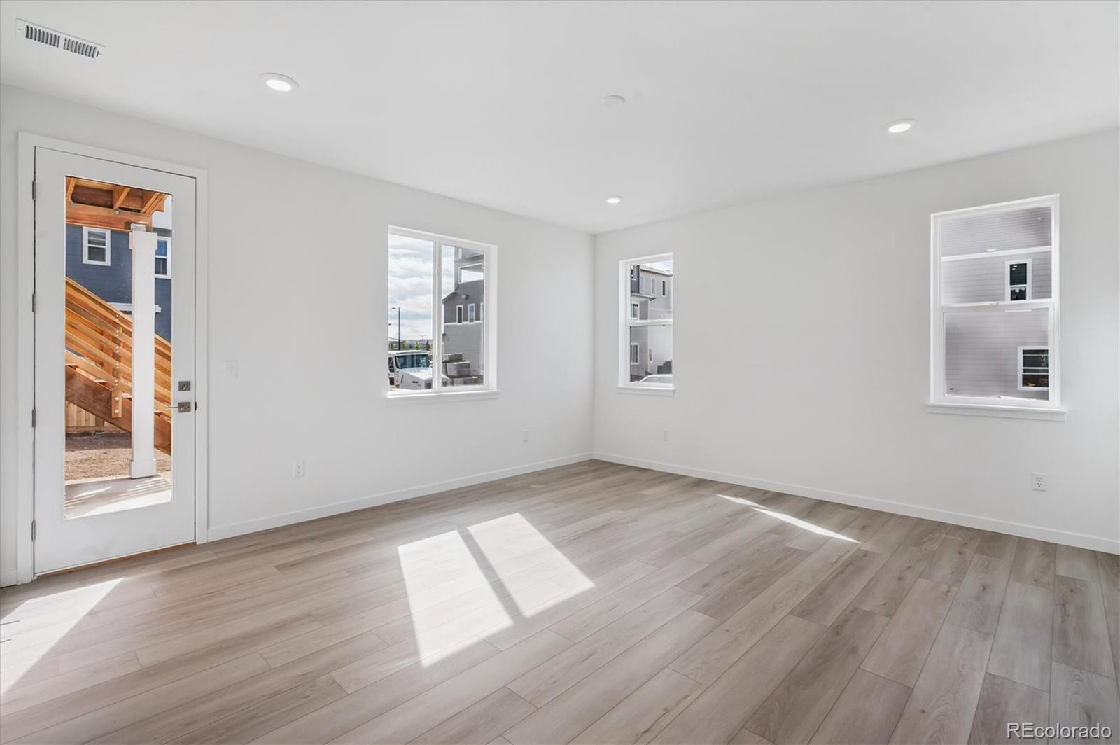 9123 White Ridge Road Englewood, CO 80112 - Photo 3 of 28 a view of an empty room with wooden floor and a window