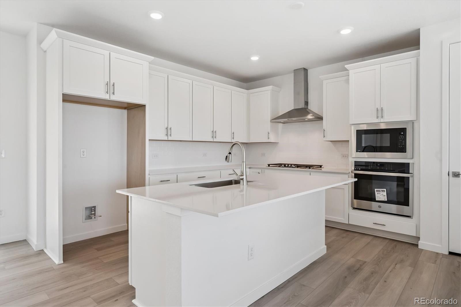9123 White Ridge Road Englewood, CO 80112 - Photo 7 of 28 a kitchen with stainless steel appliances granite countertop a white stove top oven and white cabinets