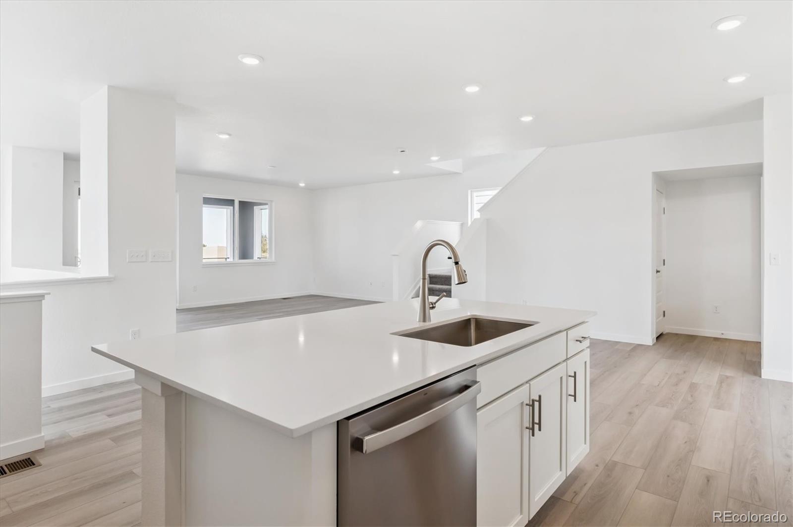 9123 White Ridge Road Englewood, CO 80112 - Photo 8 of 28 a kitchen with stainless steel appliances a sink and wooden floor