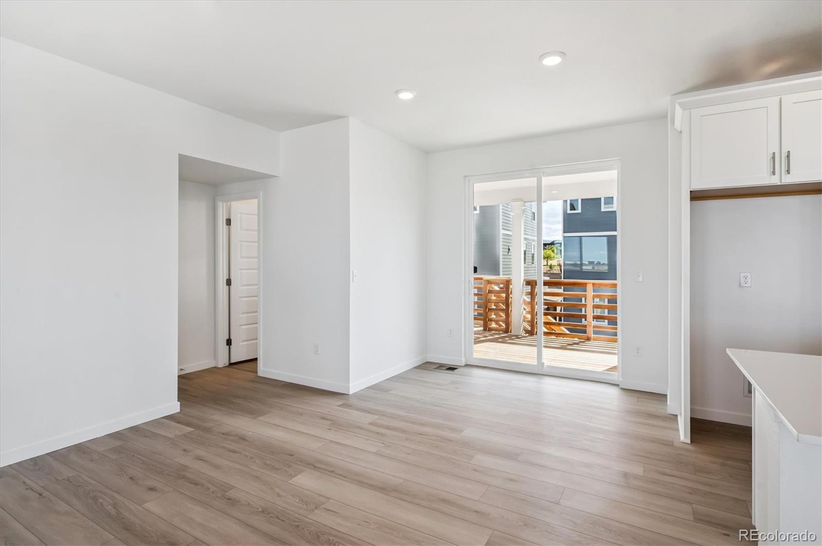 9123 White Ridge Road Englewood, CO 80112 - Photo 10 of 28 a view of an empty room with wooden floor and a window