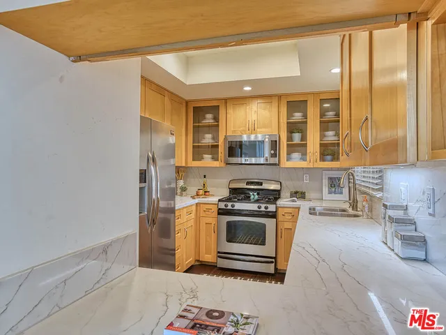 a kitchen with stainless steel appliances granite countertop a stove a sink and a refrigerator