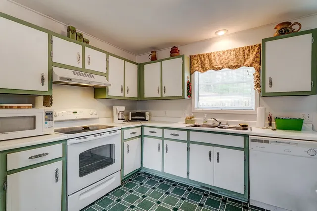 a kitchen with white cabinets sink and appliances