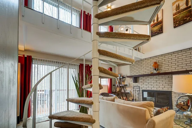 a living room with furniture a fireplace and a large window