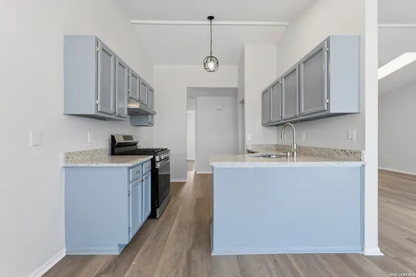 a kitchen with stainless steel appliances granite countertop a sink a stove and a refrigerator