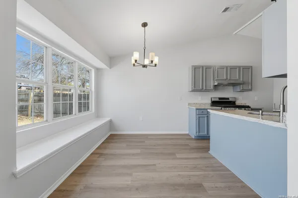 a kitchen with granite countertop a stove and a wooden floors