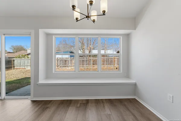 a view of front door and bedroom with wooden floor and windows