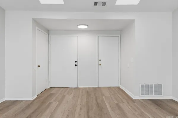 a view of an empty room with wooden floor
