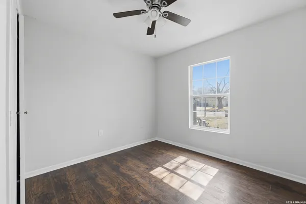 an empty room with windows and fan