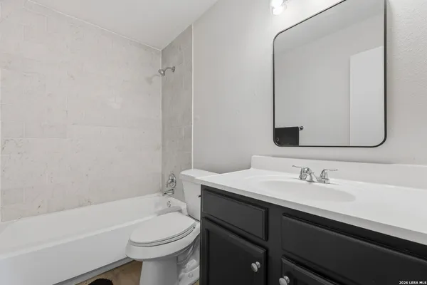 a bathroom with a sink toilet vanity and tub
