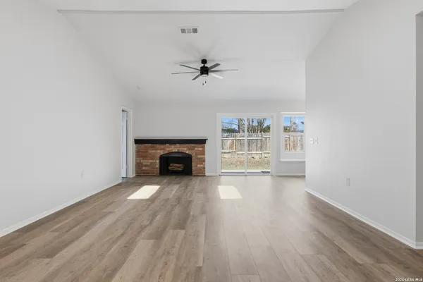 an empty room with windows and fireplace