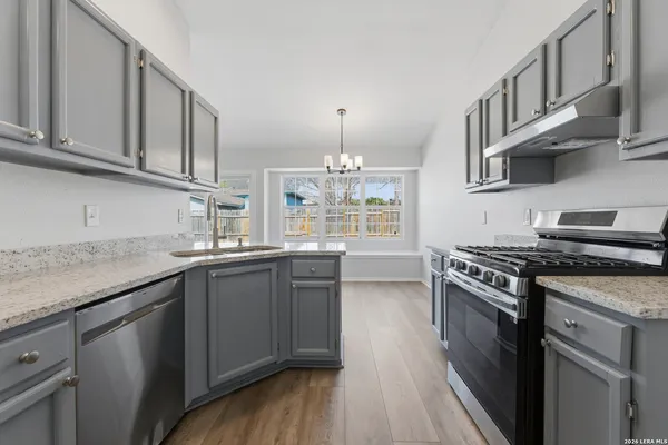 a kitchen with stainless steel appliances granite countertop a stove and a sink