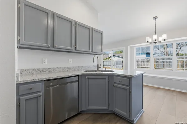 a kitchen with granite countertop stainless steel appliances a sink and cabinets