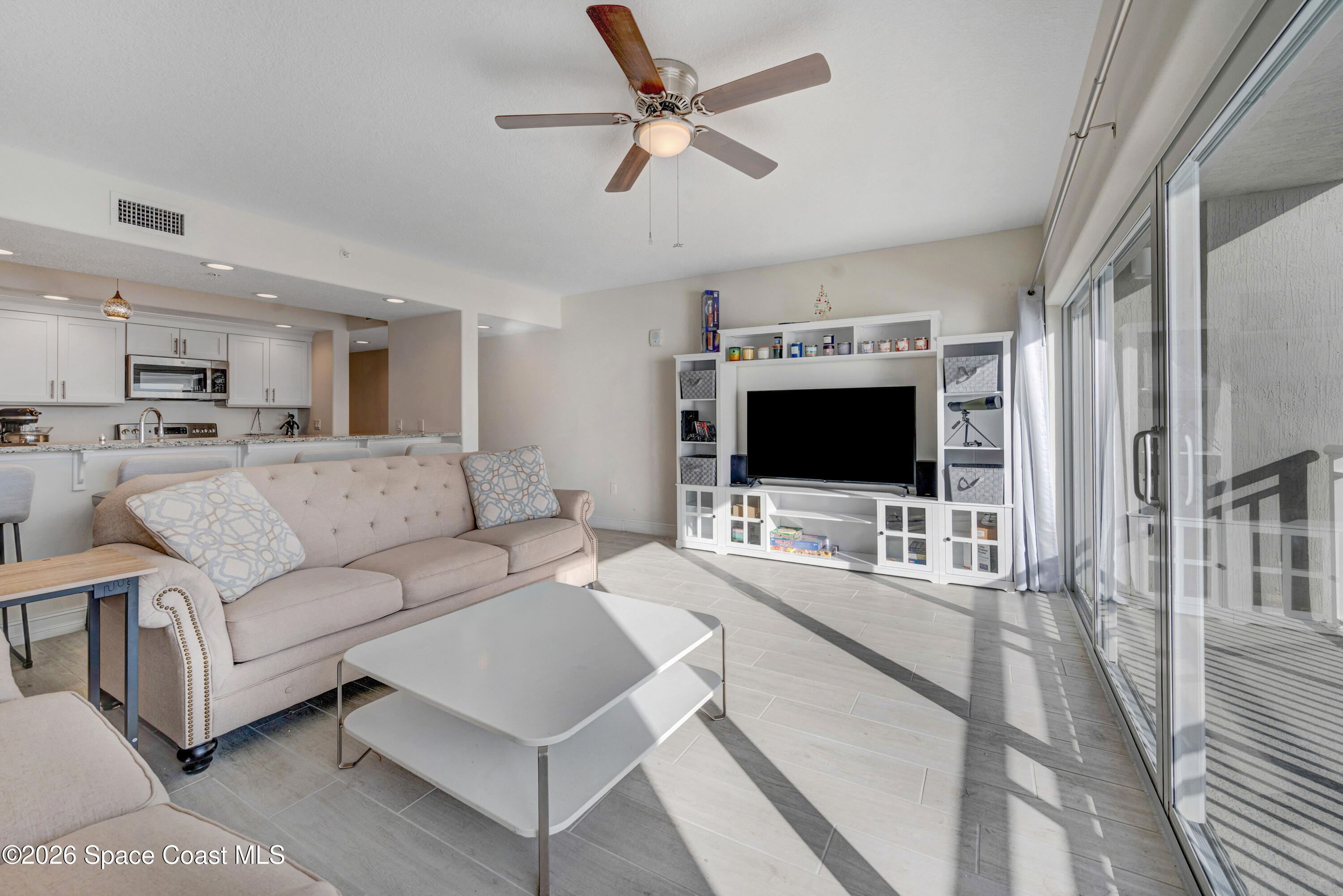1825 Riverside Drive, Unit 204 Titusville, FL 32780 - Photo 13 of 29 a living room with furniture a flat screen tv and a dining table