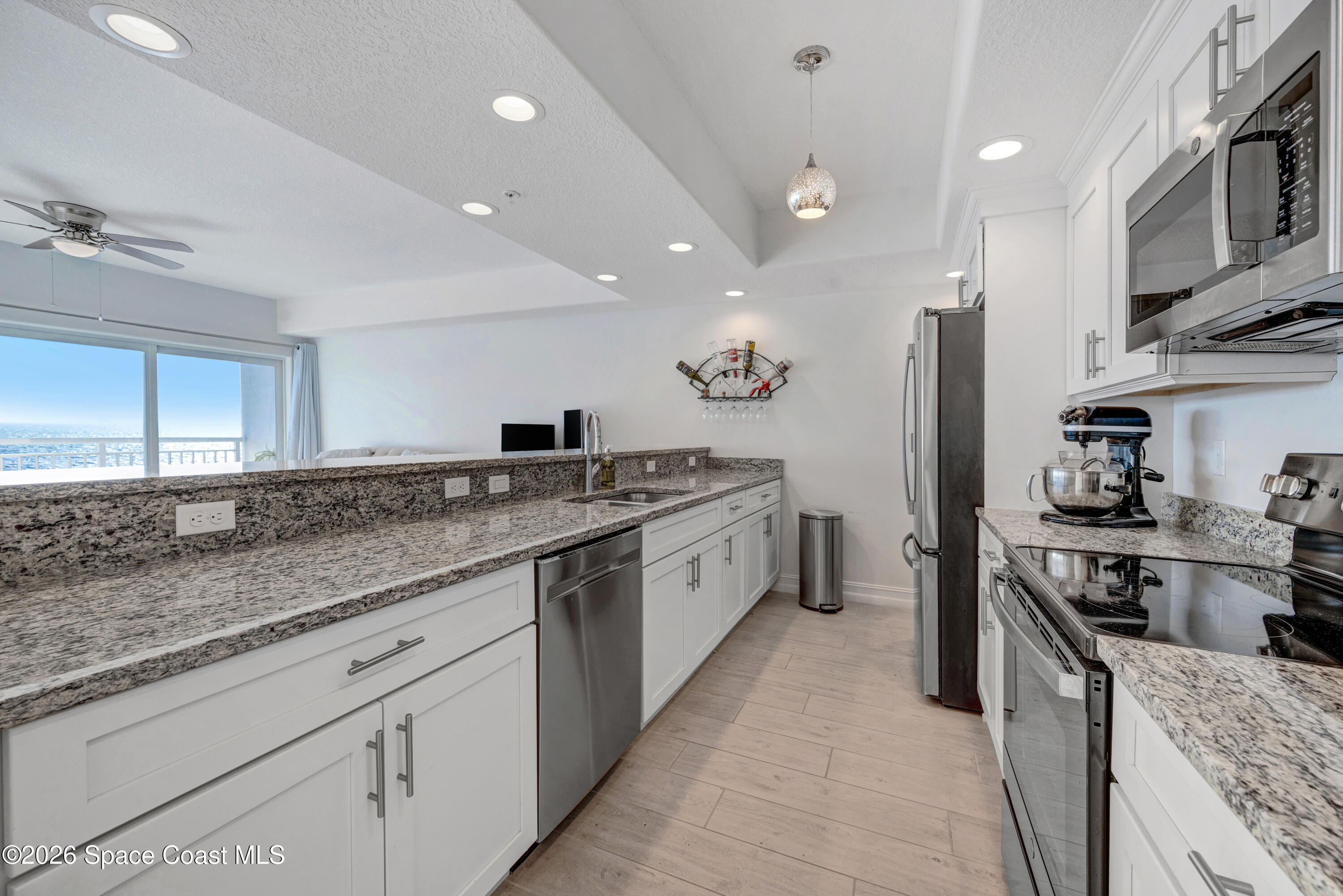 1825 Riverside Drive, Unit 204 Titusville, FL 32780 - Photo 14 of 29 a large kitchen with stainless steel appliances granite countertop a lot of counter space and wooden floors
