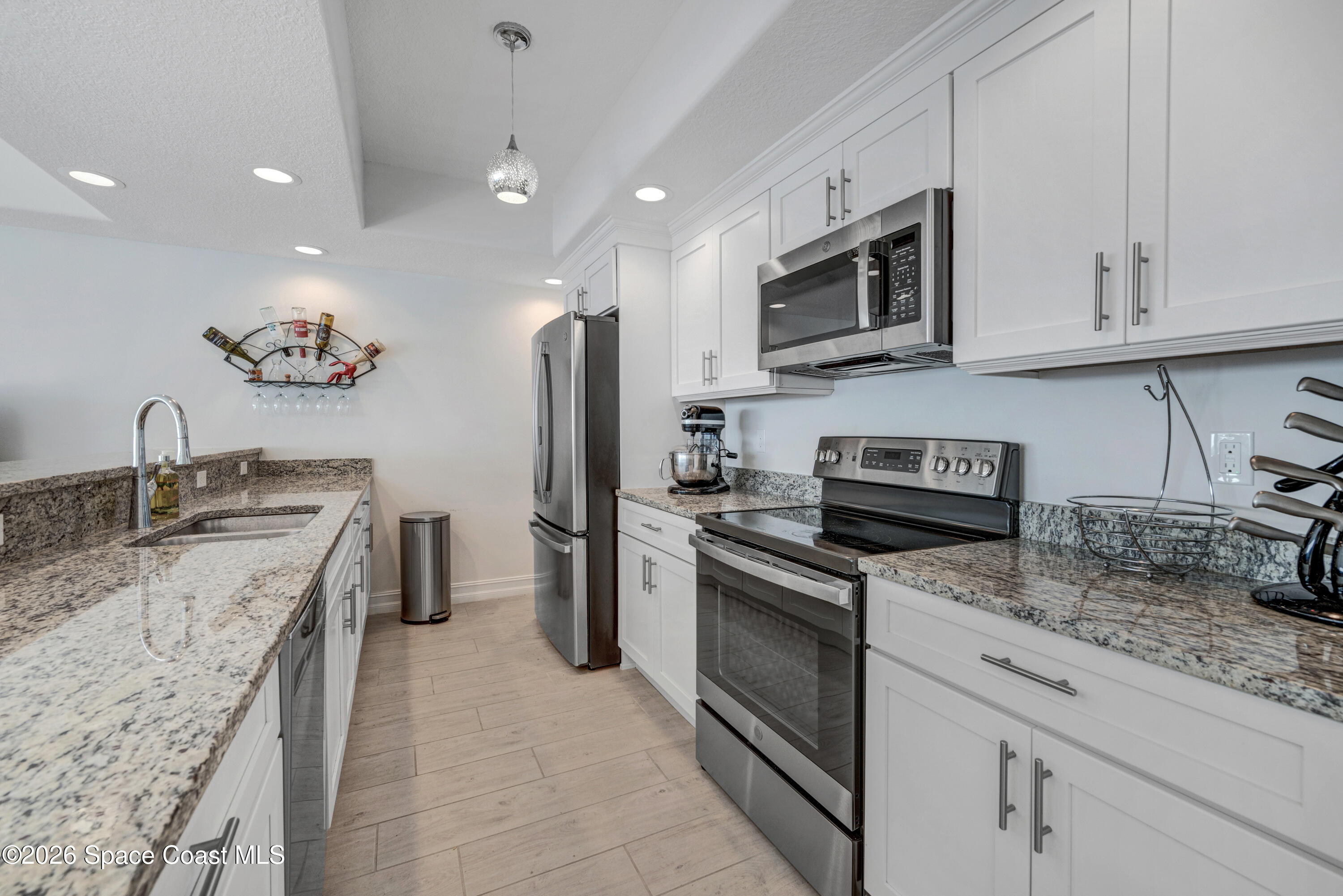 1825 Riverside Drive, Unit 204 Titusville, FL 32780 - Photo 15 of 29 a kitchen with stainless steel appliances granite countertop a sink stove and refrigerator