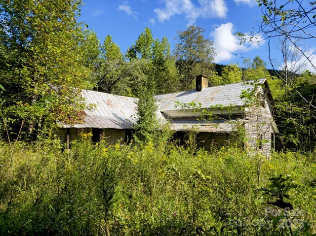 a view of a house with pool and a yard
