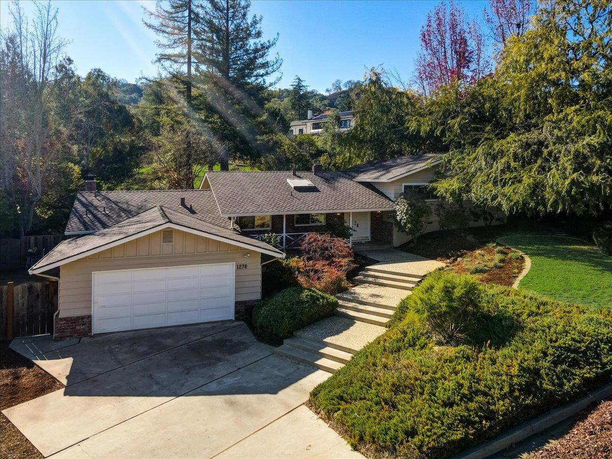 a front view of a house with a yard and potted plants