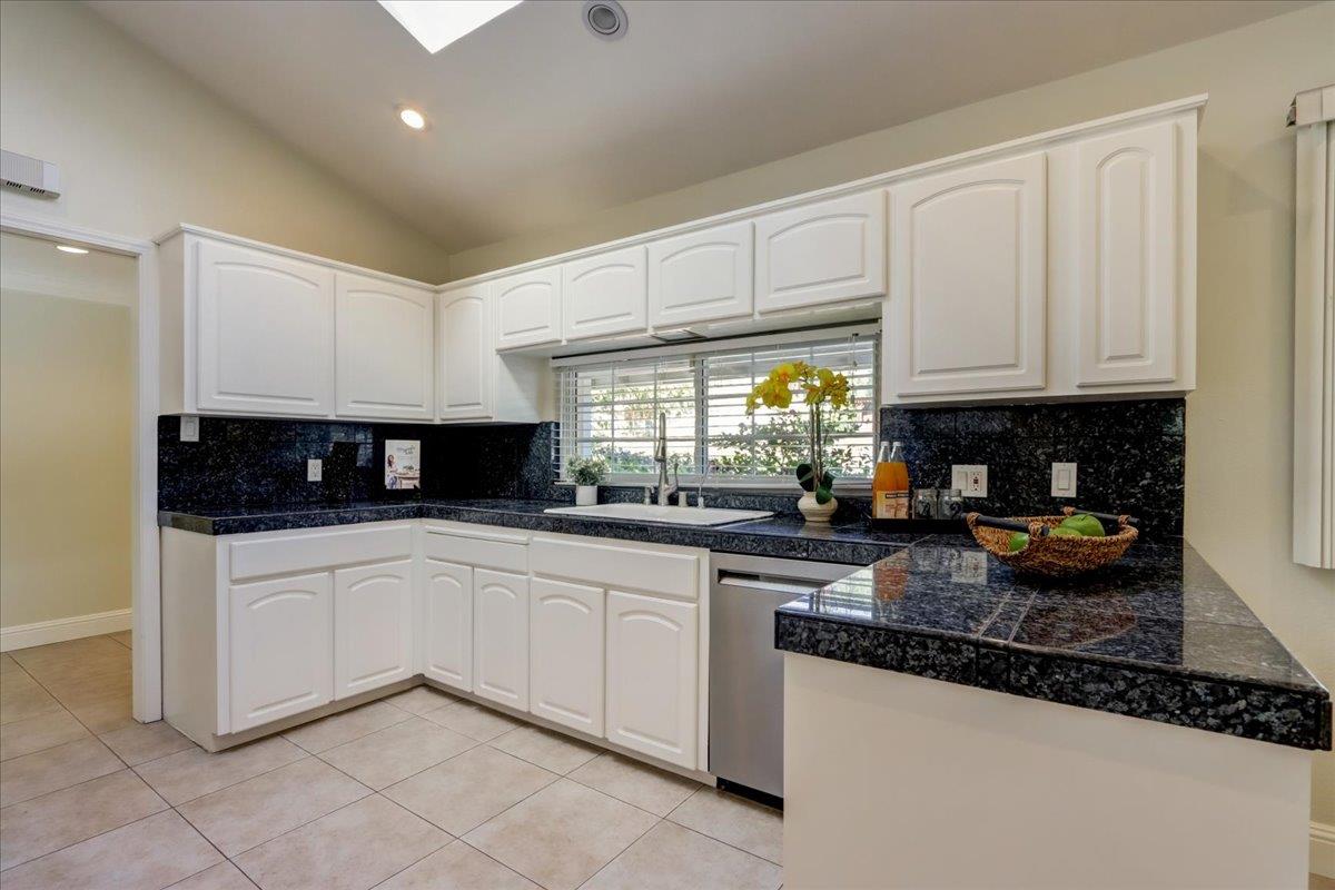 1276 Echo Valley Drive San Jose, CA 95120 - Photo 18 of 54 a kitchen with granite countertop a sink white cabinets and a stove