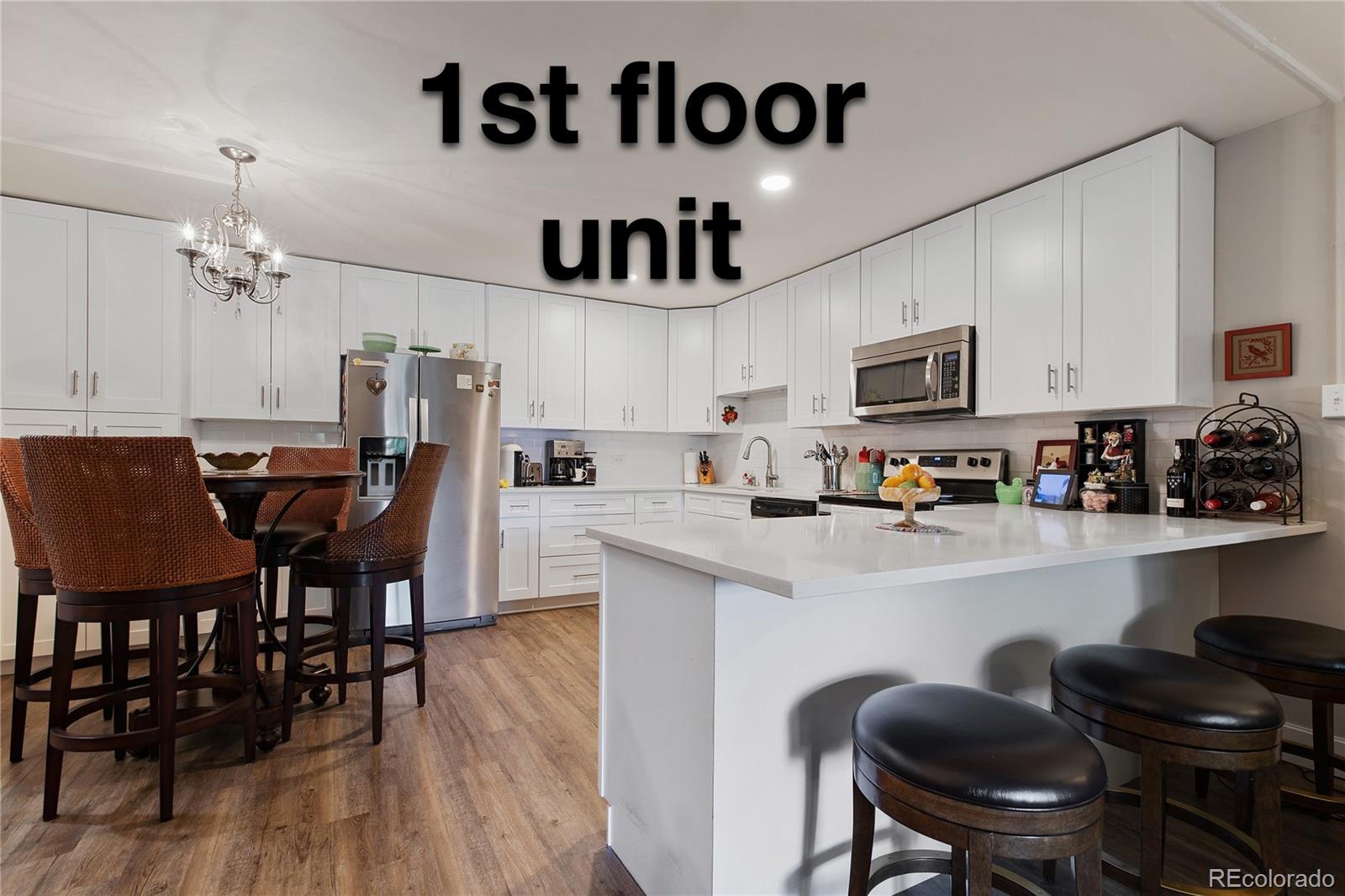 a kitchen with kitchen island a dining table chairs and a refrigerator