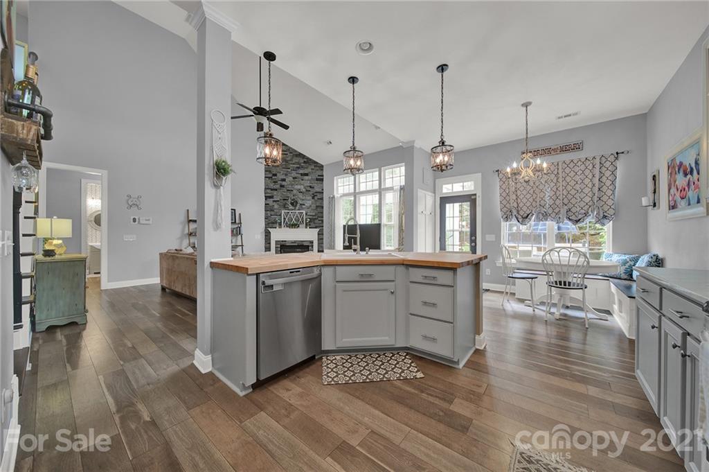 324 Miners Cove Way Fort Mill, SC 29708 - Photo 14 of 48 a kitchen with stainless steel appliances granite countertop a stove a sink dishwasher a refrigerator and a dining table with wooden floor