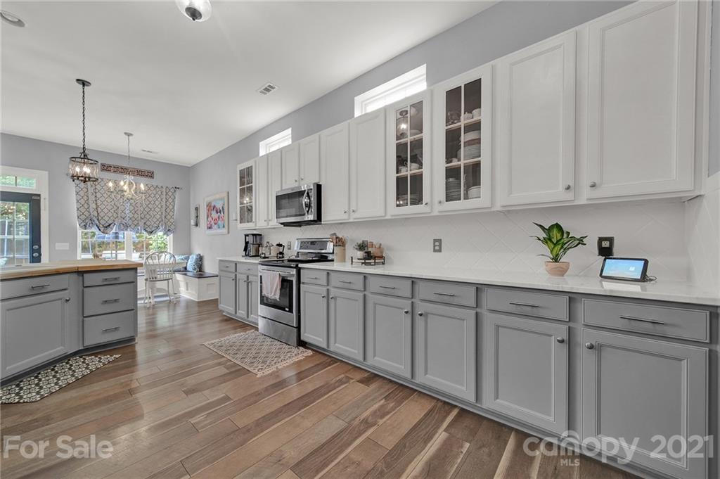 324 Miners Cove Way Fort Mill, SC 29708 - Photo 15 of 48 a kitchen with granite countertop white cabinets and white appliances