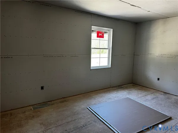 an empty room with windows and painting